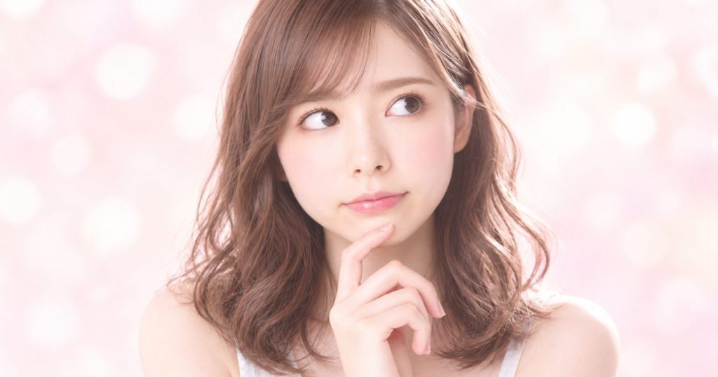 ピンクの光の中で、ふと考えごとをする様子のイメージ