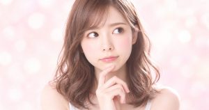 ピンクの光の中で、ふと考えごとをする様子のイメージ