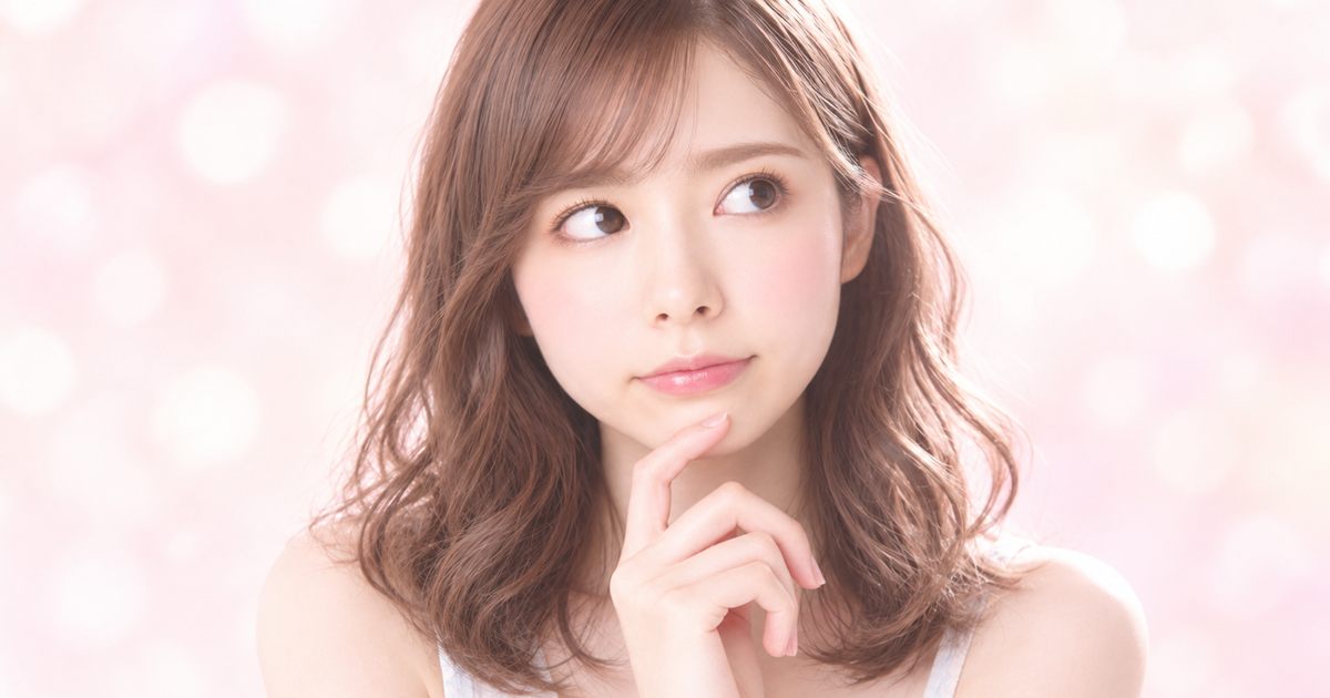 ピンクの光の中で、ふと考えごとをする様子のイメージ